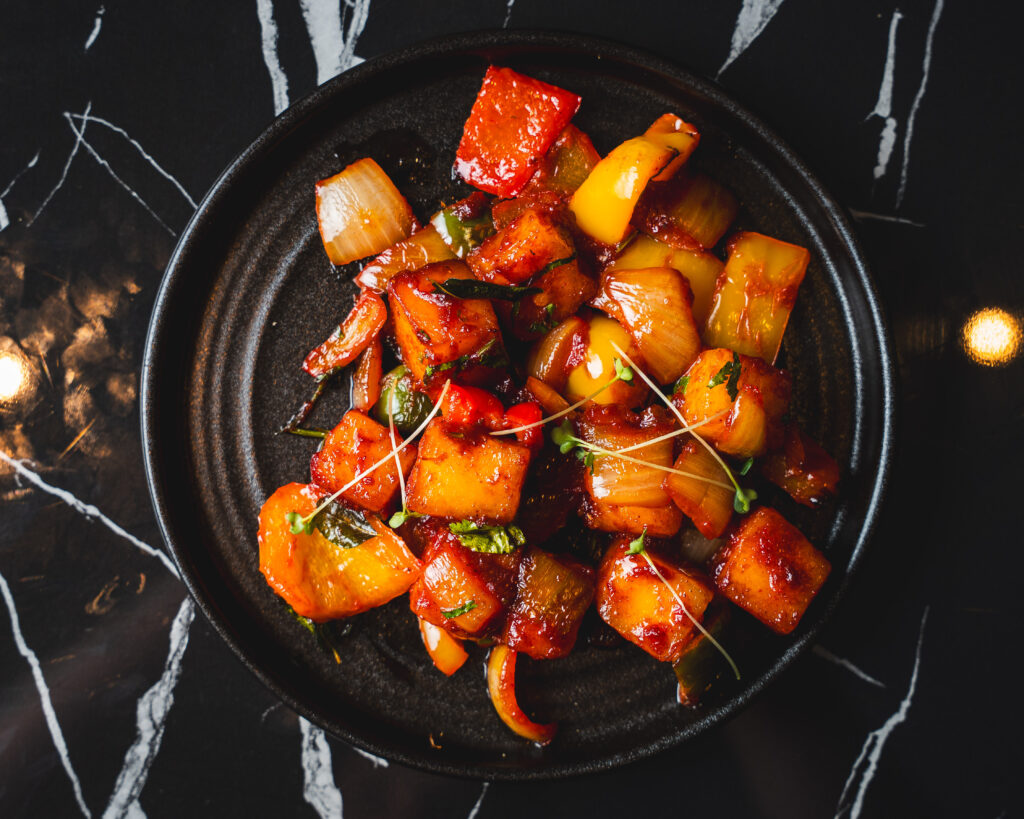 Golden-fried cubes of fresh cottage cheese (paneer) tossed with crisp bell peppers, onions, and spring greens in a vibrant, savory Indo-Chinese sauce. Perfected with garlic, ginger, soy, and a kick of fiery green chillies. Available dry or in a rich gravy.