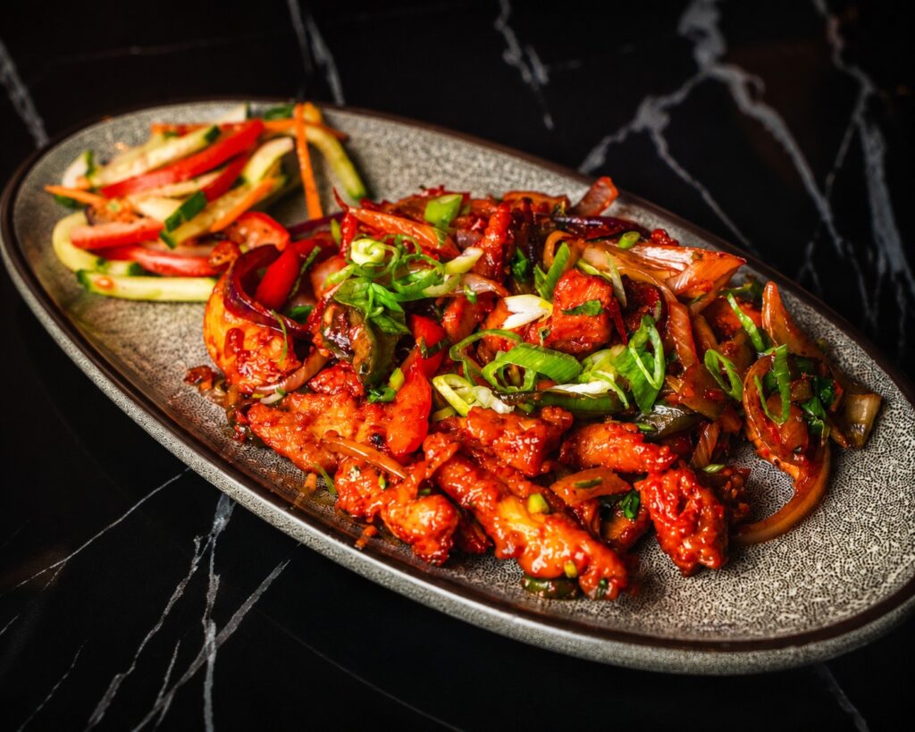 Crispy fried chicken tossed in fiery sauce and garnished with sesami seeds